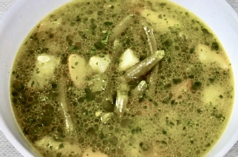 Zupa jarzynowa na bazie bulionu warzywnego z dodatkiem fasolki szparagowej, bobu i cukinii doprawiona domowym pesto bazyliowym.