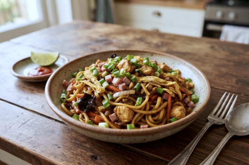 Bami Goreng to makaron wymieszany ze smażonymi kawałkami kurczaka, cebulą oraz warzywami, szynką i siekanym omletem.