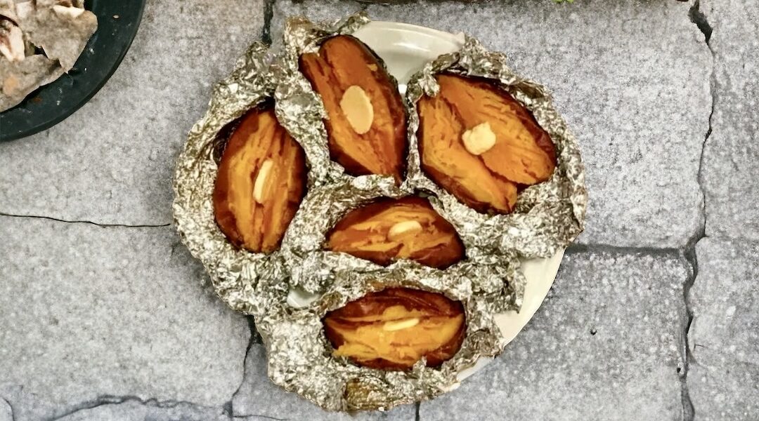 Bataty skropione oliwą, posypane solą morską, zawinięte w folię aluminiową i pieczone do miękkości.