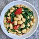 Gotowana biała fasolka wymieszana z przesmażonym boczkiem oraz świeżą papryką, ziemniakami i szpinakiem.