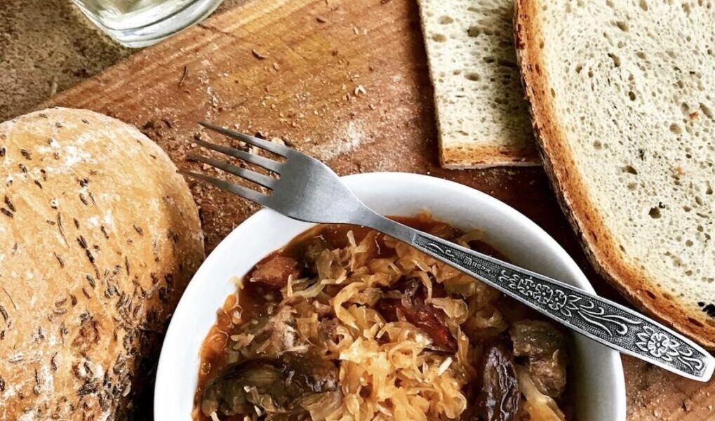 Tradycyjny bigos myśliwski z dziczyzną przygotowany z kapusty kiszonej z dodatkiem kilku rodzajów mięs, suszonych śliwek, grzybów i polskiej żubrówki dla smaku.