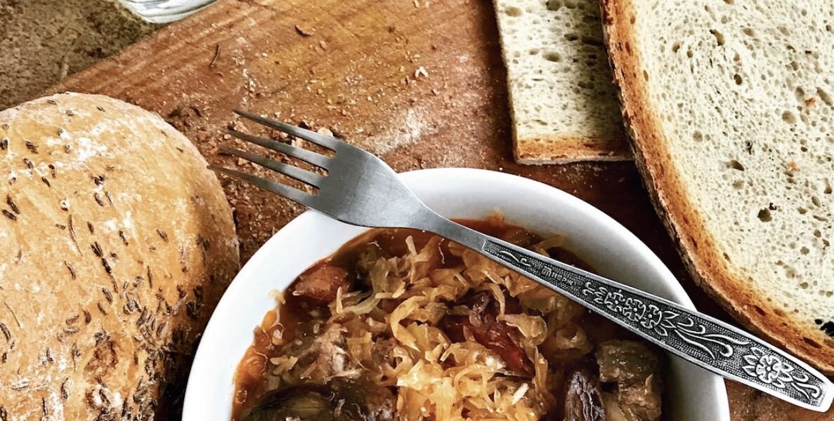 Tradycyjny bigos myśliwski z dziczyzną przygotowany z kapusty kiszonej z dodatkiem kilku rodzajów mięs, suszonych śliwek, grzybów i polskiej żubrówki dla smaku.