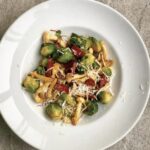 Gotowana brukselka smażona z plastrami chorizo i grzybami shimeji na koniec posypana parmezanem.