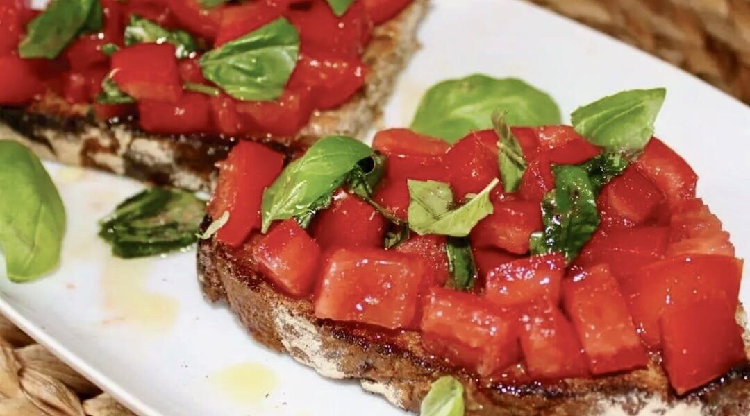 Bruschetta z pomidorami to grillowana i polana obficie oliwą kromka wiejskiego chleba z pomidorami, świeżą bazylią i solą morską.