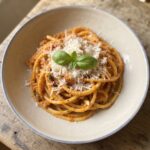 Makaron bucatini alla trapanese podany z pesto przyrządzonym z migdałów, pomidorków koktajlowych, sera pecorino i świeżej bazylii.