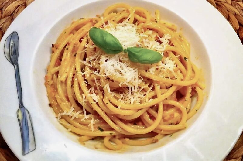 Makaron bucatini alla trapanese podany z pesto przyrządzonym z migdałów, pomidorków koktajlowych, sera pecorino i świeżej bazylii.