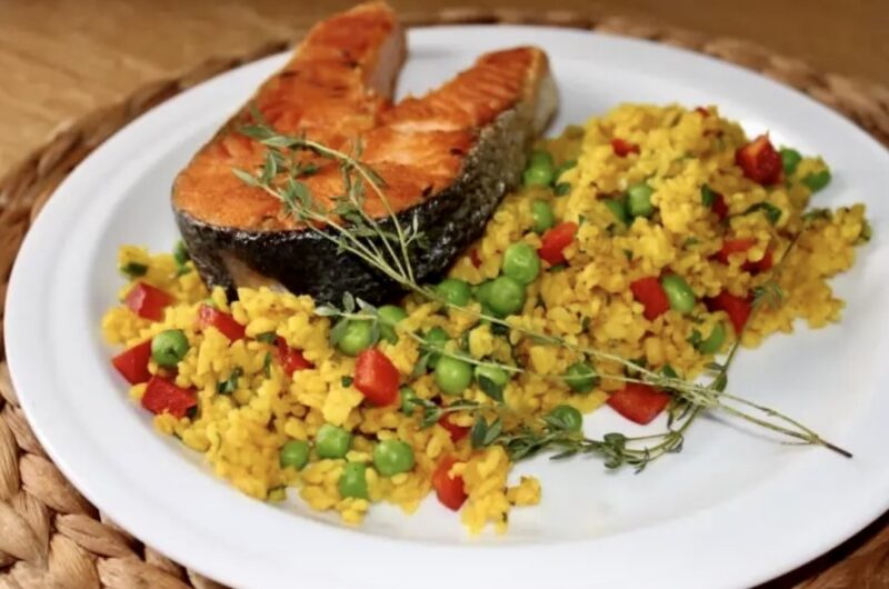 Bulgur gotowany z przyprawami i mieloną kurkumą, a następne zmieszany z warzywami w postaci papryki i groszku.