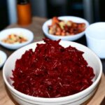 Ugotowane, obrane i starte buraki czerwone zasmażane i doprawione kminkiem i kwaśną śmietaną.