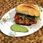 Burger rybny przygotowany z filet z dorsza smażonego i podanego w bułce z dodatkiem sosu z kaparów, sałaty, pietruszki i korniszonów.