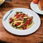 Chłopskie jadło to sycący posiłek przygotowany z makaronu z dodatkiem przesmażonych na cebuli kawałków kiełbasy oraz z fasolką szparagową i świeżą papryką.