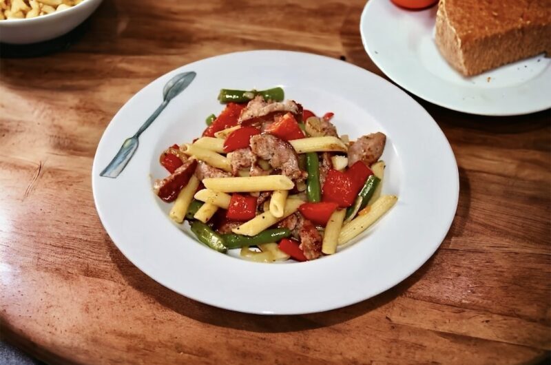 Chłopskie jadło to sycący posiłek przygotowany z makaronu z dodatkiem przesmażonych na cebuli kawałków kiełbasy oraz z fasolką szparagową i świeżą papryką.