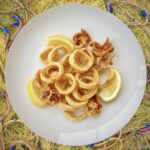 kalmary pokrojone w krążki, a następnie obsypane mąką i krótko smażone na oliwie