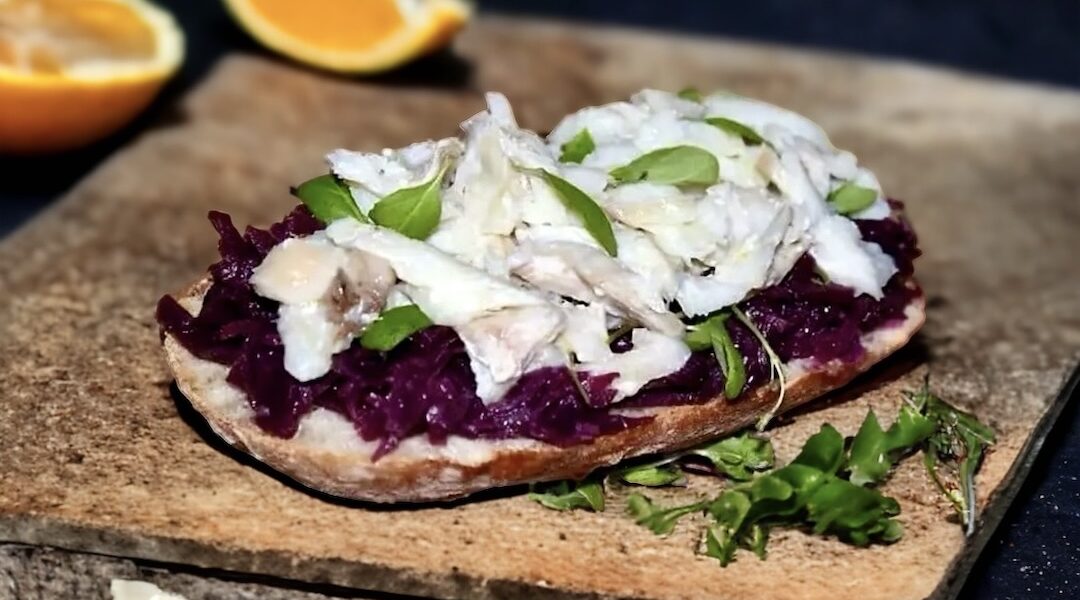 Puszysta ciabatta, czyli włoska bułka pszenna podana z dorszem pieczonym z kiszoną lub duszoną czerwoną kapustą.