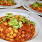 Ciecierzyca duszona po indyjsku w aromatycznych przyprawach z pomidorach i świeżą kolendrą.