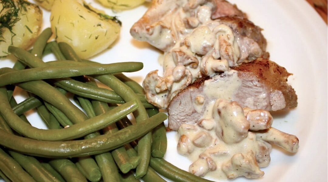 Marynowany w rozmarynie comber jagnięcy pieczony i podany w sosie kurkowym z dodatkiem śmietany.