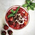 Deser owocowy przygotowany z musem bananowym z dodatkiem chili wzbogacony dojrzałymi krojonymi truskawkami i śmietaną waniliową.