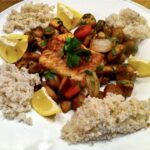 Dorsz pieczony podany z duszonymi warzywami korzeniowymi i pieczarkami.