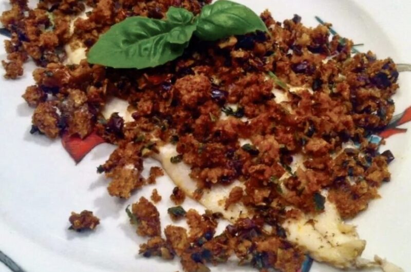 Dorsz filet przygotowany z kruszonką z czerstwego pieczywa, oliwek i suszonych pomidorów.