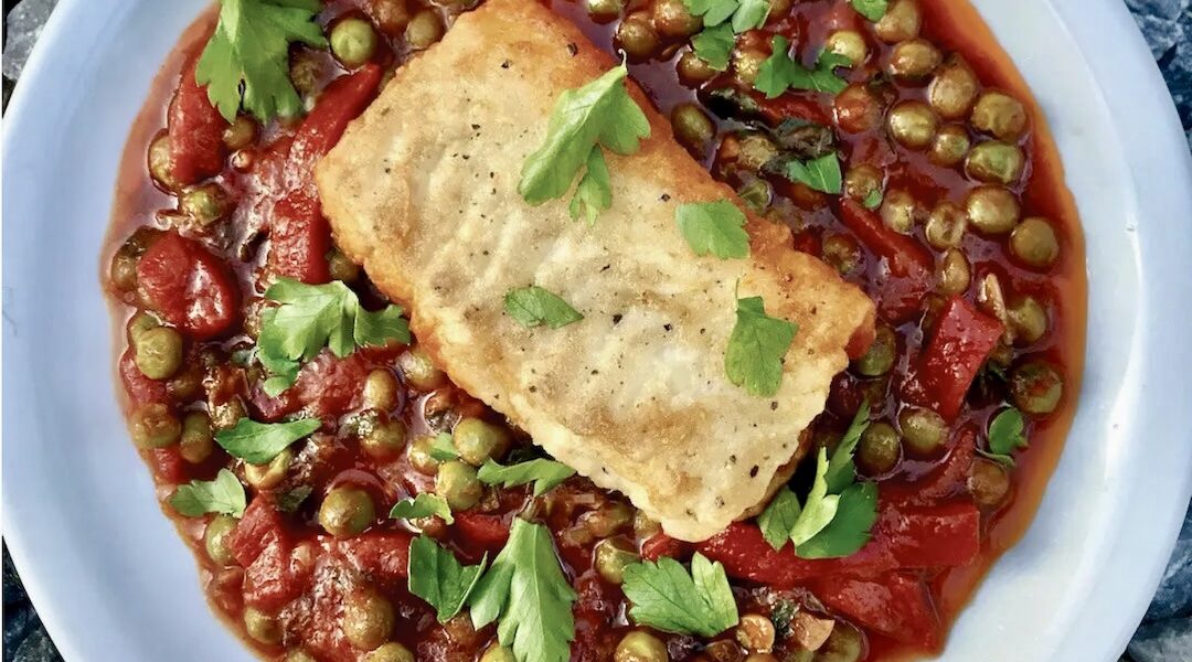 Dorsz smażony z warzywami razem z groszkiem i papryką w lekkim sosie pomidorowym.