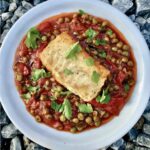 Dorsz smażony z warzywami razem z groszkiem i papryką w lekkim sosie pomidorowym.