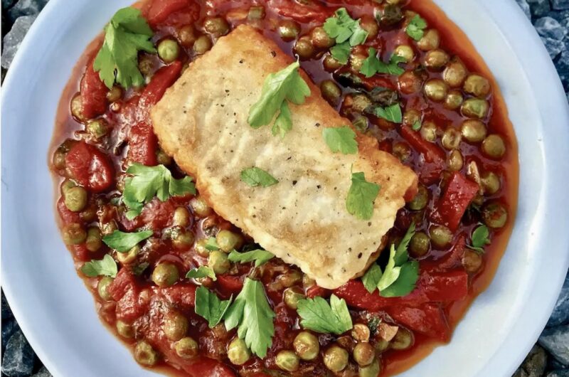 Dorsz smażony z warzywami razem z groszkiem i papryką w lekkim sosie pomidorowym.