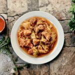 Wieprzowina duszona razem z czosnkiem, dymką i porami ze startymi pomidorami w przyprawach.