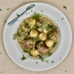 Duszony indyk z brukselką, cebulą i boczkiem wędzonym doprawiony na koniec kwaśną śmietaną.