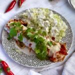 Enchilada z kurczakiem to tortilla wypełniona farszem przygotowanym z aromatycznego kurczaka w sosie pomidorowym z fasolą i serem.
