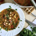 Fasolowa zupa na bazie bulionu przyrządzona ze świeżej fasolki, kiełbasy oraz startych warzyw z dodatkiem puree ziemniaczanego.