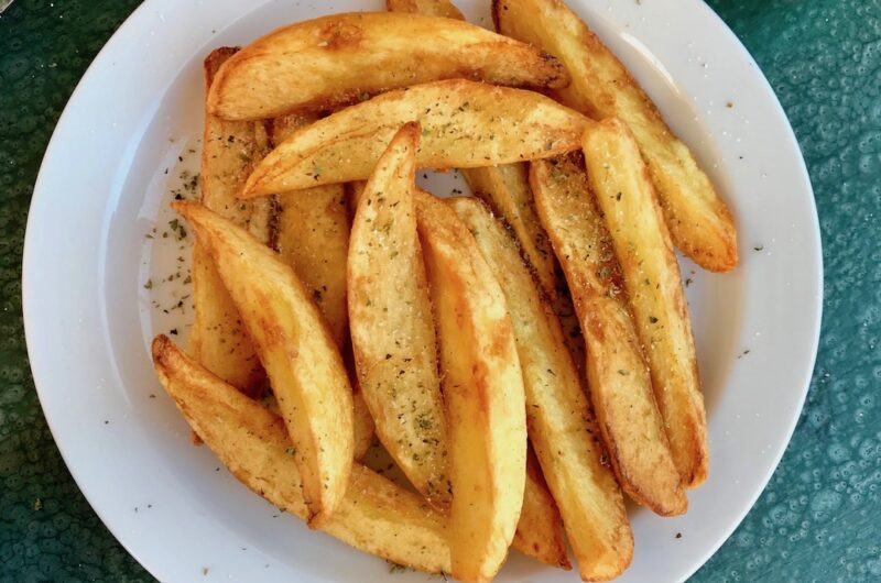 Frytki greckie to wykrojone z dużych podłużnych ziemniaków ósemki smażone w oliwie i na koniec sypane solą morską i oregano.