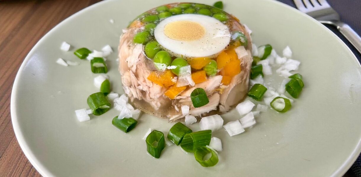 Galaretka drobiowa przygotowana z kurczaka gotowanego z warzywami, po ugotowaniu podzielonego na kawałki, umieszczonego w filiżankach i zalanego bulionem z żelatyną.