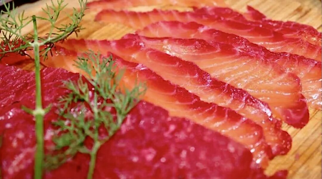 Gravlax z burakiem to płat świeżego łososia marynowany w soli z dodatkiem startego chrzanu, surowego startego buraka oraz świeżego koperku.