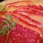Gravlax z burakiem to płat świeżego łososia marynowany w soli z dodatkiem startego chrzanu, surowego startego buraka oraz świeżego koperku.