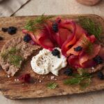 Gravlax z burakiem to płat świeżego łososia marynowany w soli z dodatkiem startego chrzanu, surowego startego buraka oraz świeżego koperku.