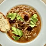 Zupa soczewicowa z Grecji przyrządzona na bulionie domowym z drobno krojonymi warzywami i soczewicą oraz startymi pomidorami.