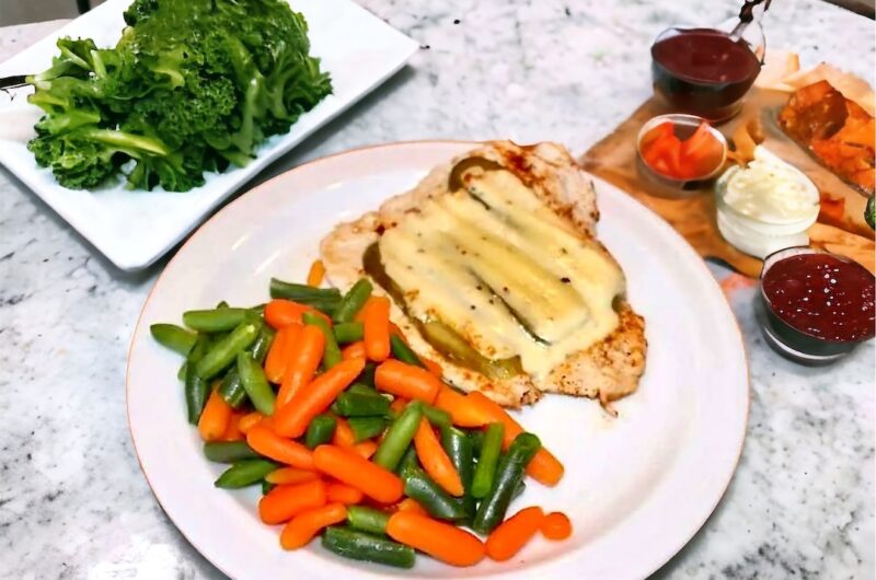 Rozbite na kotlety piersi z kurczaka krótko grillowane, a następnie zapiekane z ogórkiem kiszonym i serem raclette.