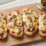 Grzanki ze stopionym serem raclette z dodatkiem suszonej wołowiny oraz korniszonów i cebulek marynowanych.