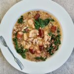 gulasz z kurczaka z frankfurterkami i jarmużem na talerzu