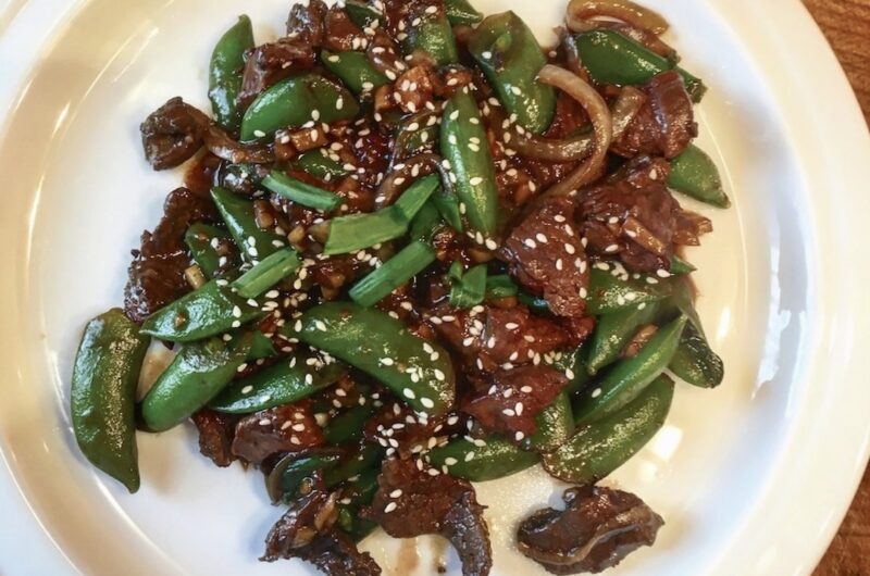 Jagnięcina pokrojona na małe kawałki marynowana w sosie sojowym i oleju sezamowym, a następnie smażona z imbirem, czosnkiem i dymką podawana z groszkiem cukrowym.