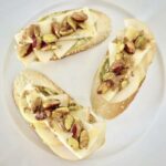 Kanapka przygotowana z kromki pieczywa z dodatkiem awokado obłożonej plastrami gruszki, serem gorgonzolą oraz pistacjami w miodzie i cynamonie.