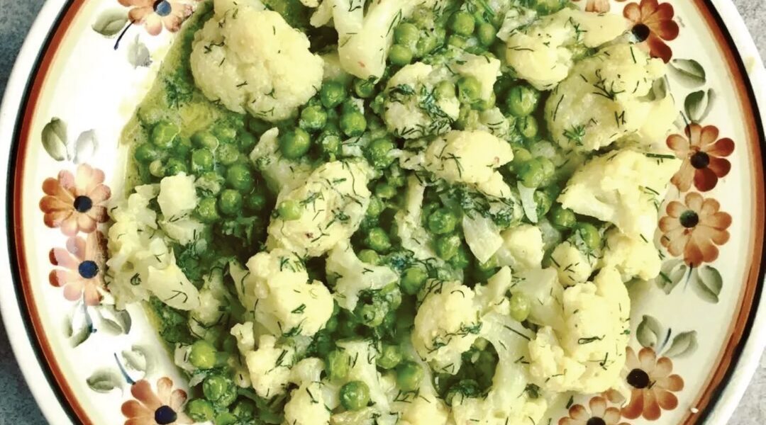 Kalafior z groszkiem krótko smażone, a następnie duszone i podane w sosie cytrynowym przyrządzonym z jajek oraz soku z cytryny.