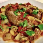 Kiełbasa surowa wieprzowa duszona z dodatkiem krojonych papryk oraz ze startymi pomidorami i suszonym oregano.