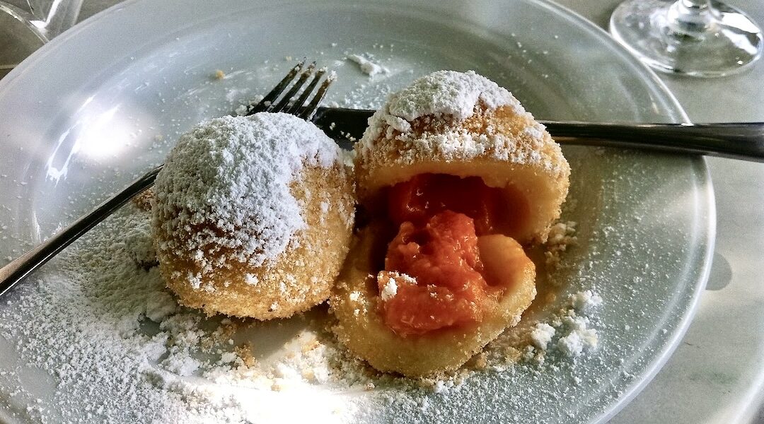 Knedle z morelami przyrządzone zostało z ciasta z twarogu i mąki pszennej. Rozpłaszczone kawałki ciasta wypełnione zostały najpierw dojrzałymi morelami bez pestek, a następnie uformowane w knedle, gotowane i podawane w bułce tartej z cukrem pudrem.