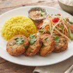Kotleciki rybne przyrządzone z dorsza mielonego z dodatkiem pasty curry, sosu rybnego, sosu sojowego i limonki smażone bezpośrednio przed podaniem.