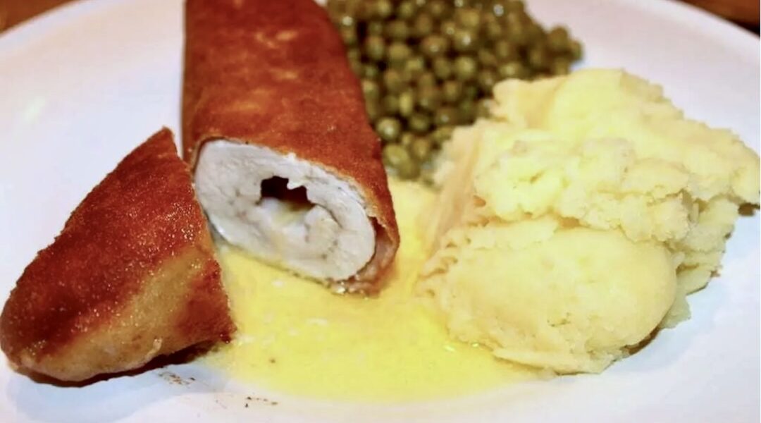 Kotlet de Volaille przygotowany z piersi kurczaka wypełniony masłem, zwinięty w roladę, panierowany, a następnie smażony powoli na maśle.