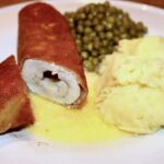 Kotlet de Volaille przygotowany z piersi kurczaka wypełniony masłem, zwinięty w roladę, panierowany, a następnie smażony powoli na maśle.