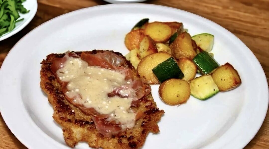 Kotlet cielęcy przygotowany po bolońsku, czyli panierowany i smażony, a następnie obłożony szynką parmeńską i płatkami parmezanu na koniec krótko duszony.