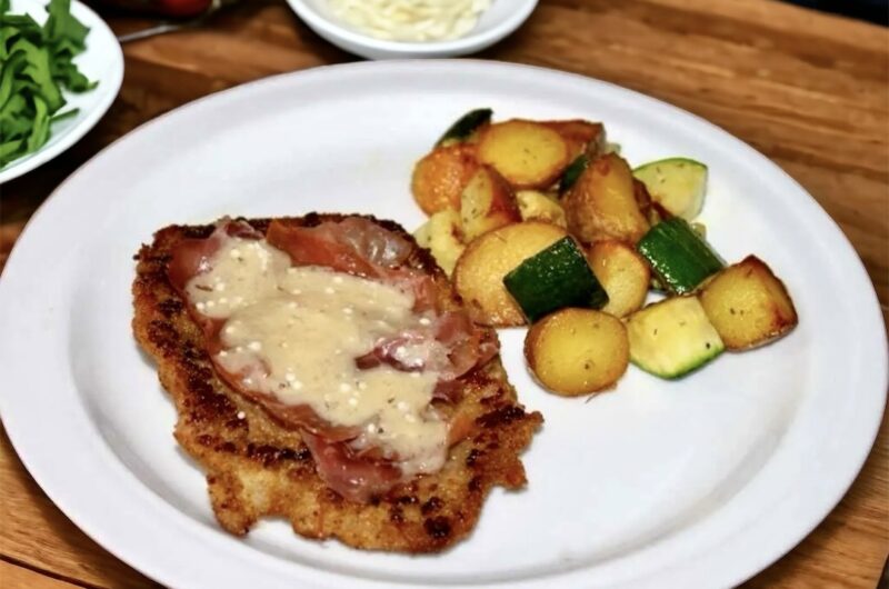 Kotlet cielęcy przygotowany po bolońsku, czyli panierowany i smażony, a następnie obłożony szynką parmeńską i płatkami parmezanu na koniec krótko duszony.