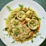 Kotlety wieprzowe duszone razem z karczochami, groszkiem i ziemniakami na koniec skropione sokiem z cytryny.