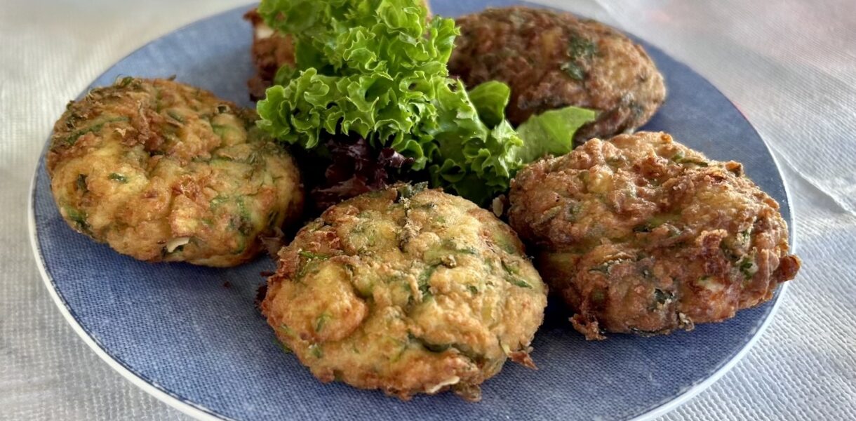 Placki z cukinii czyli starte cukinie zmieszane z serem feta oraz świeżymi ziołami, a następnie formowane w placki i smażone.